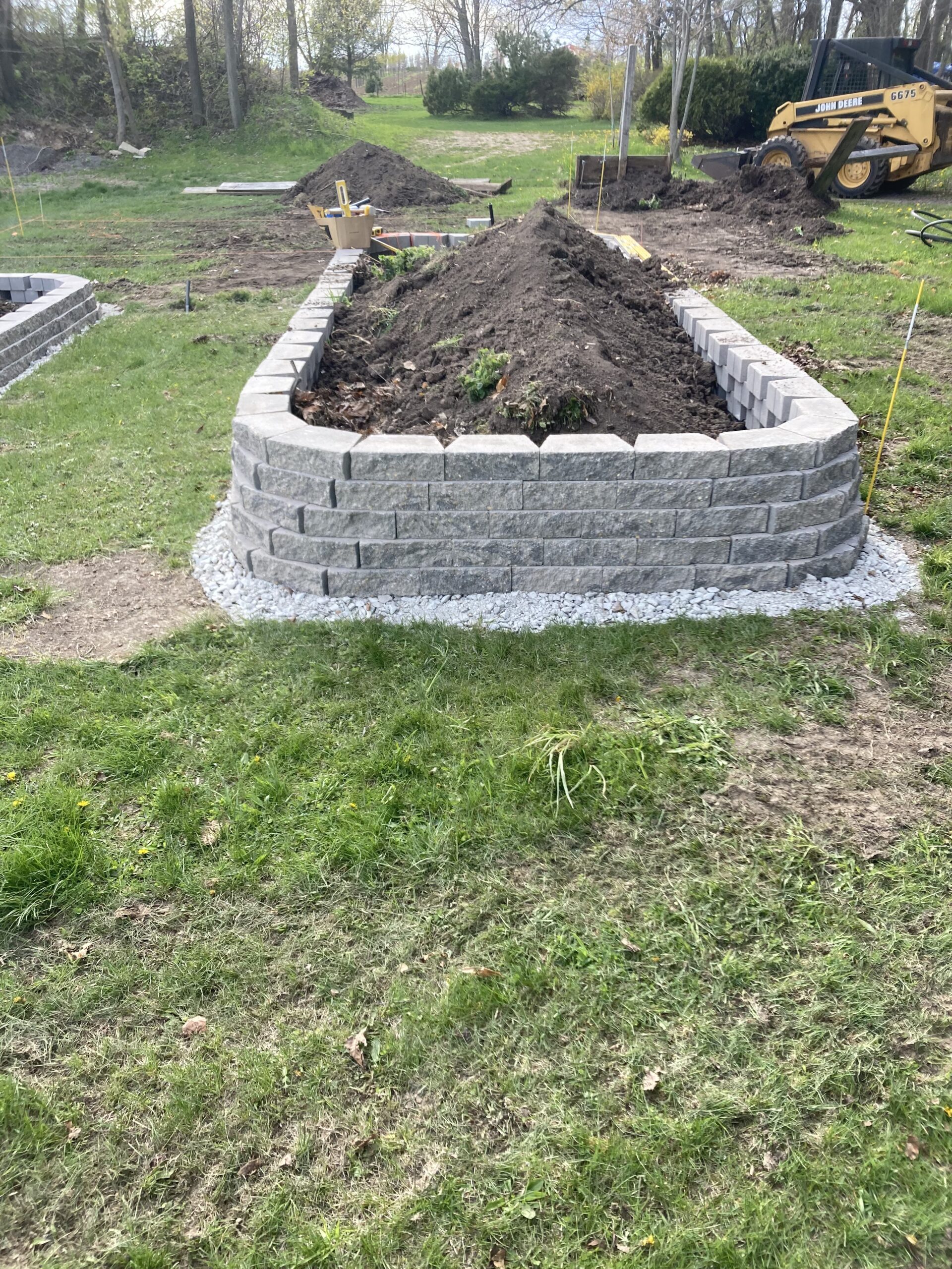 Limestone boulder retaining wall and planting bed installation