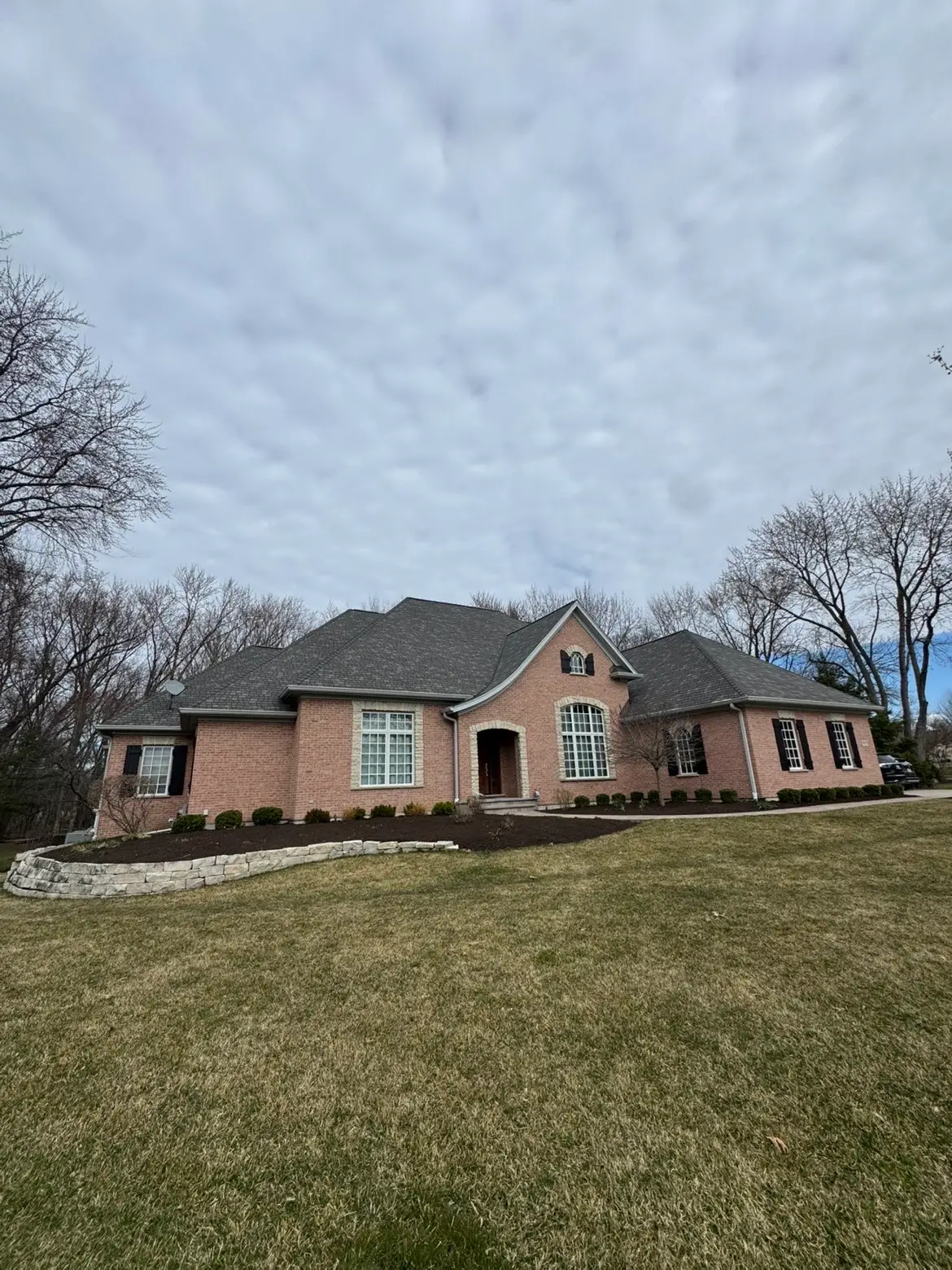 Front yard landscape with limestone retaining wall and fresh mulch