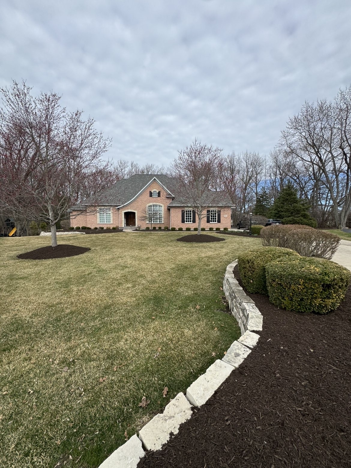 Limestone edged mulch beds and manicured front lawn