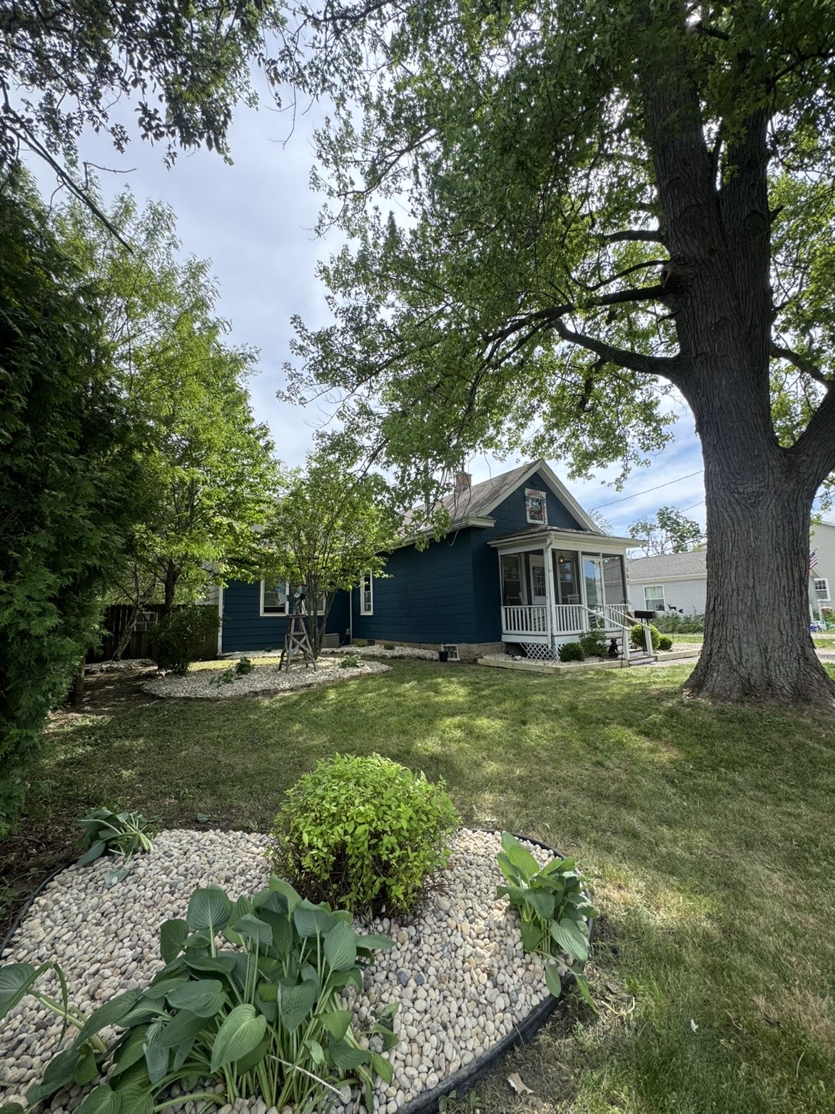 Cottage landscape with river rock beds and timber edging